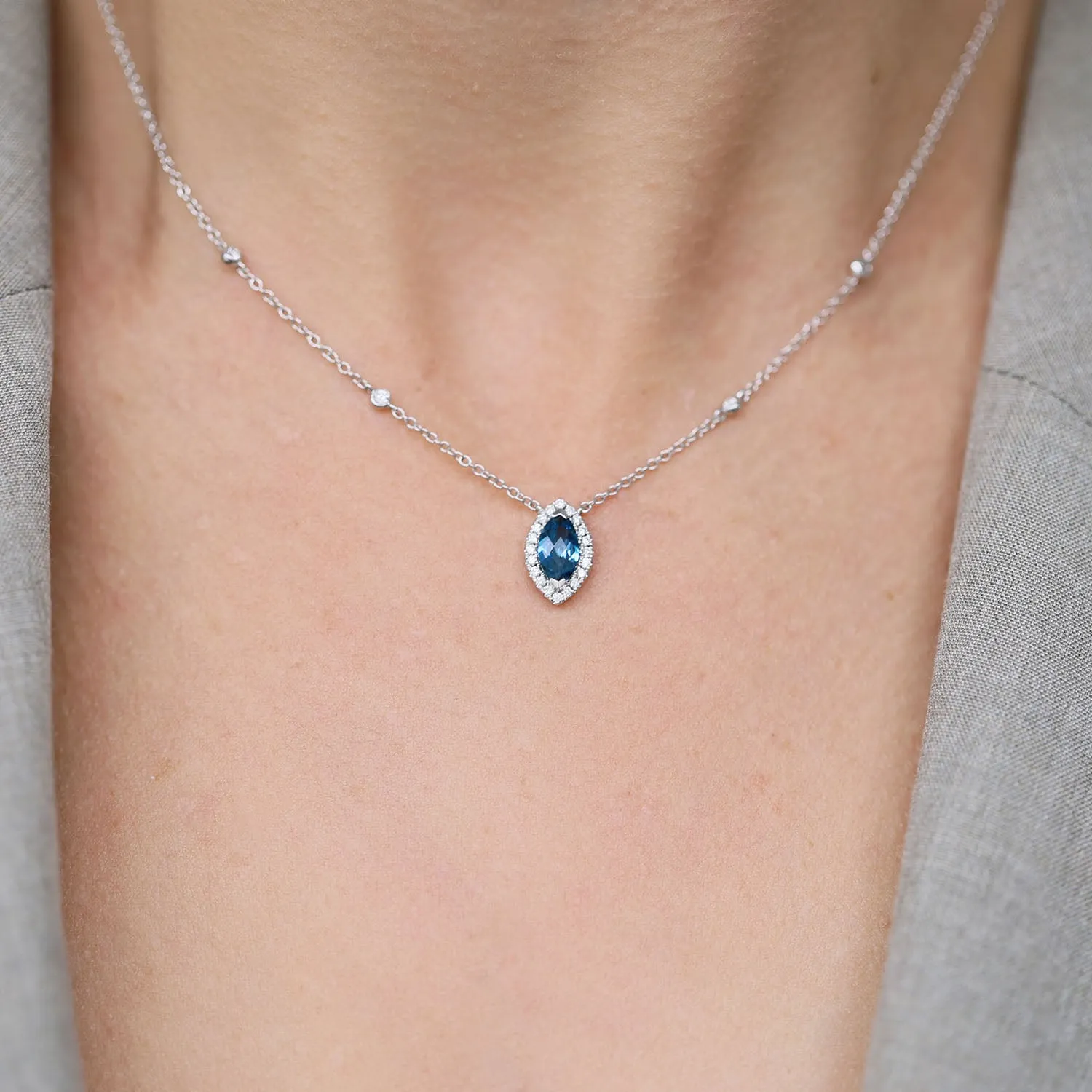 18ct White Gold Marquise London Blue Topaz And Diamond Halo Pendant With Diamonds On The Chain